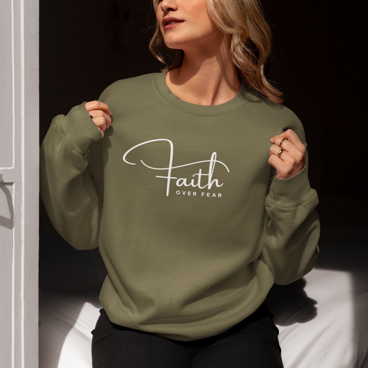 Woman wearing "Faith Over Fear" sweatshirt in Military Green