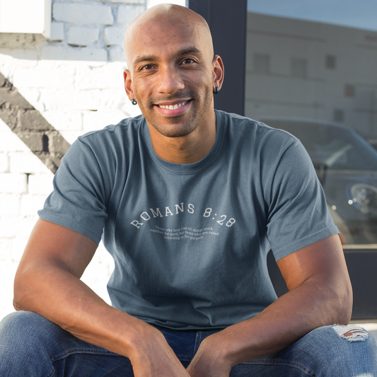 Man wearing a blue t-shirt with text, sitting on steps outdoor