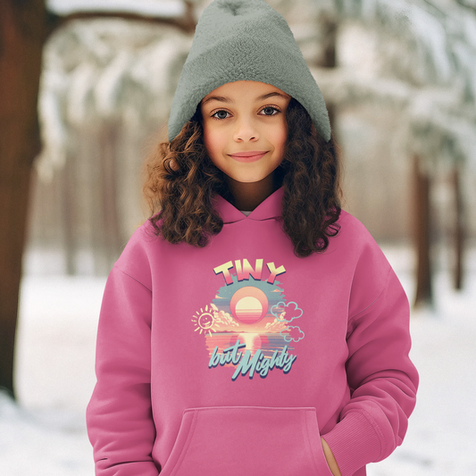 Child wearing a pink hoodie with a graphic design in a snowy outdoor setting