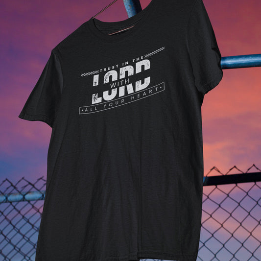 Black t-shirt with text design hanging against a sunset sky.
