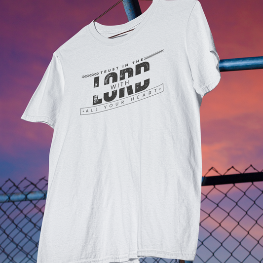White t-shirt with text design hanging against a sunset sky.