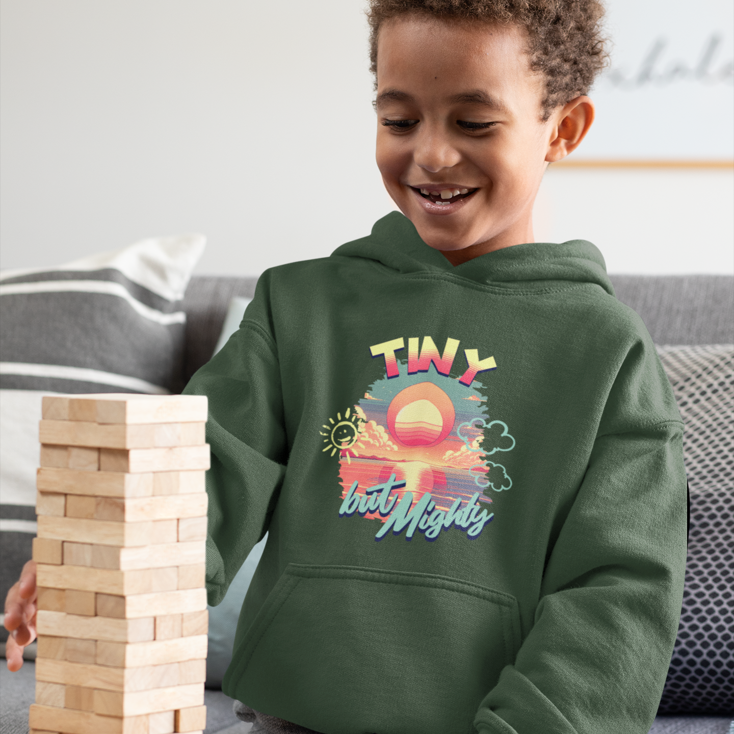 Child playing with wooden blocks wearing a green hoodie with a colorful design.