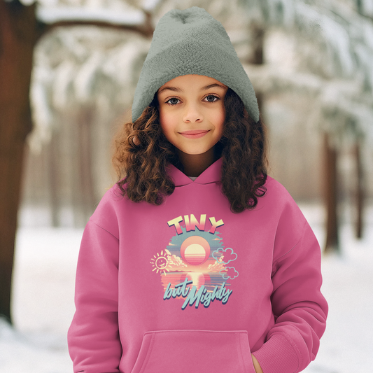 Child wearing a pink hoodie with a graphic design in a snowy outdoor setting