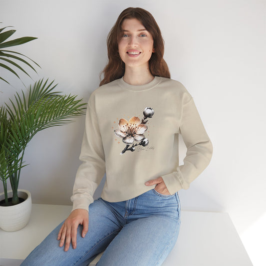 Woman wearing a beige sweatshirt with a floral design, sitting on a white surface with a plant in the background.