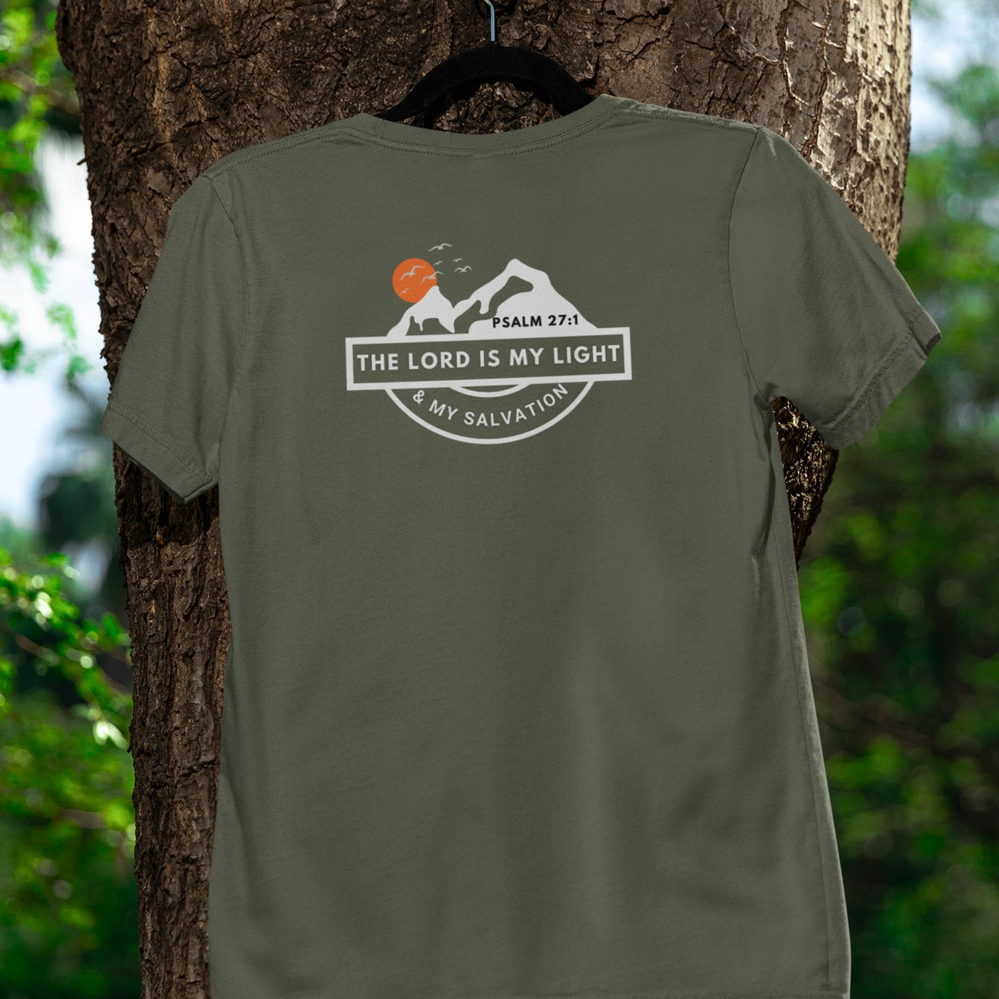 Green t-shirt with a graphic design hanging on a tree