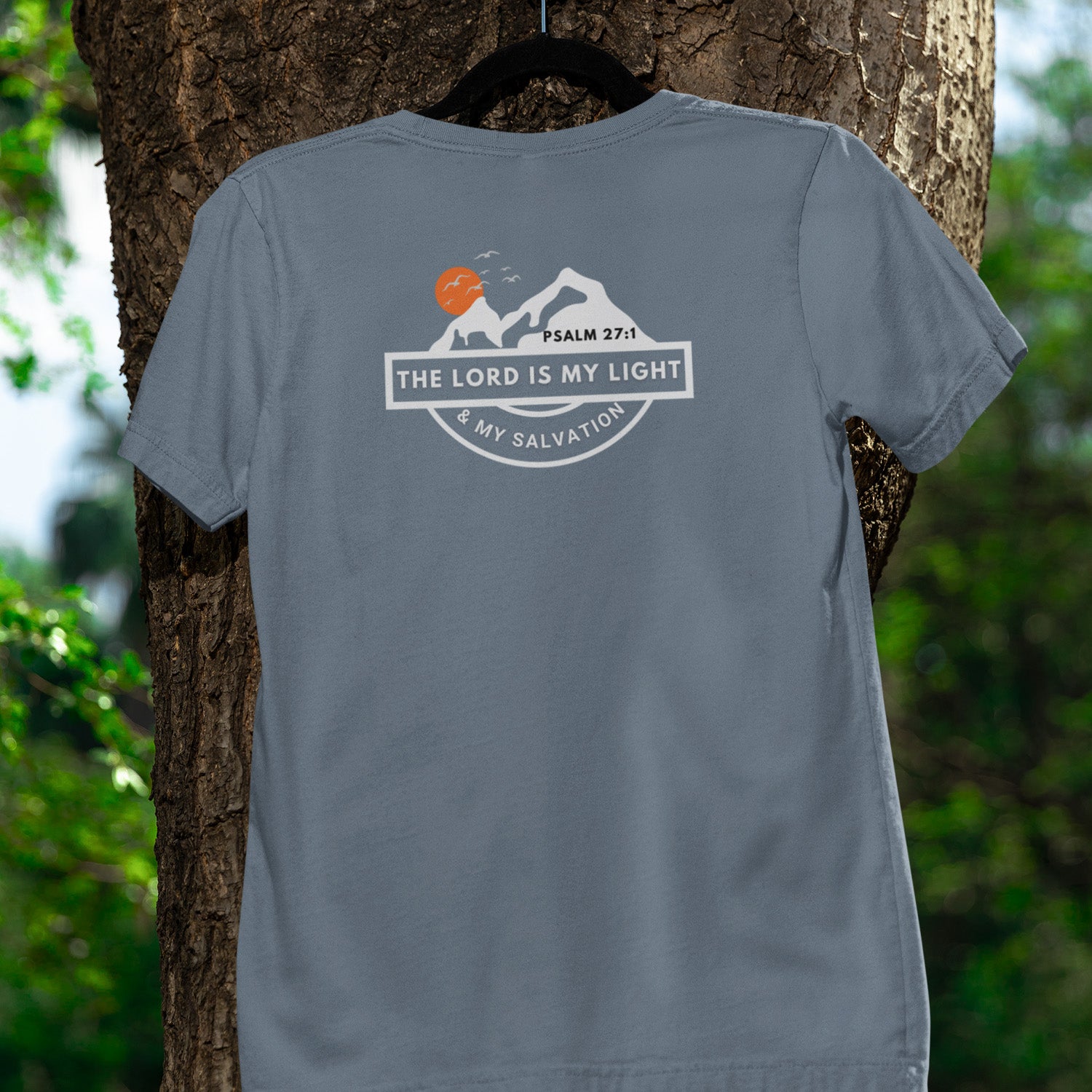 Gray t-shirt with a motivational design on the back, hanging on a tree